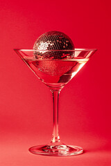 Cocktail party with disco ball on sunset coral color background. Disco party, retro fashion. Modern stylish banner template for holiday card, banner, flyer, menu with space for text