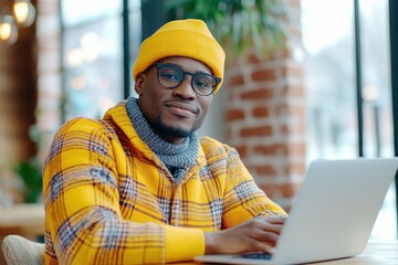 Young Entrepreneur Working Intently on a Laptop at a Cozy Coffee Shop With Warm Ambiance