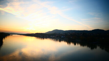 oranger Himmel spiegelt sich in der Donau, Abenddämmerung über Melk