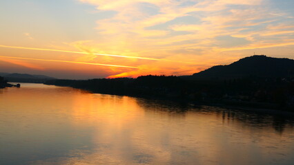 Obraz premium Oranger Himmel spiegelt sich in der Donau, bei Melk