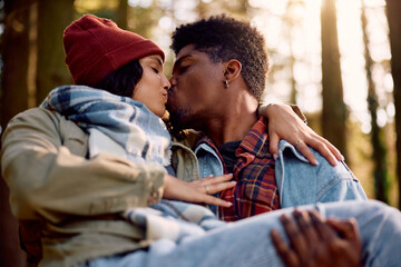 Obraz premium Young couple in love kissing in autumn at sunset.