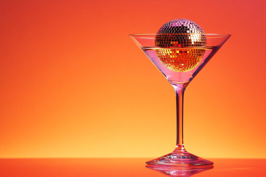 Cocktail party with disco ball on bright red color background. Disco party, retro fashion. Modern stylish backdrop template for holiday card, banner, flyer, menu with space for text