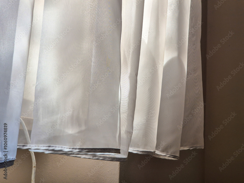 Poster light filtering through sheer curtains, creating a soft ambiance in a cozy room