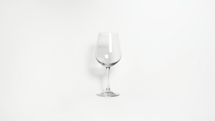 A single, empty wine glass set against a clean white background, casting a soft shadow. 