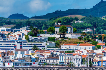 Obraz premium A view from a boat towards the shores and the Hermitage of the Mother of God at Ponta Delgada on the island of San Miguel in the Azores in summertime