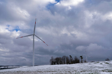A winter landscape featuring wind turbines