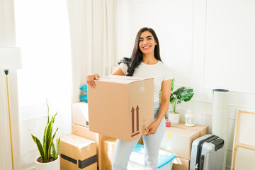 Happy woman unboxing a package in her new living room