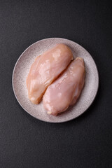 Fototapeta premium Pieces of raw chicken or turkey fillet with salt, spices and herbs