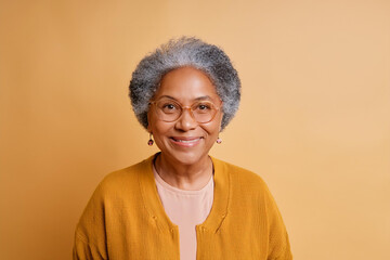 Beautiful age. Headshot portrait of happy mature female pensioner looking at camera with white smile.