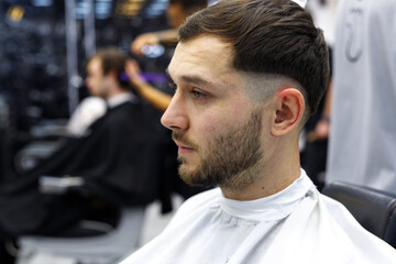 Men's haircut in a barbershop or beauty salon. Hairdressing services in a barbershop.