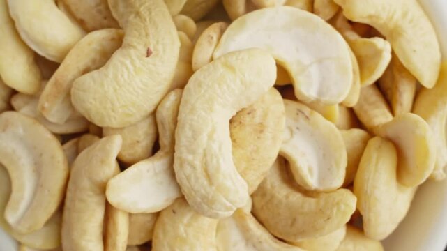 Variety of different colored raw healthy food. Nuts and dried fruits. cashew, almonds, walnuts, peanuts dried apricots, hazelnut, prunes rotating. Dolly zoom out. Healthy food concept. 4K, UHD