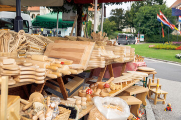 Handmade wooden kitchen utensils displayed at vibrant outdoor market