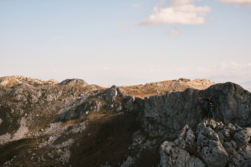Fototapeta premium Beautiful mountain landscape with people hiking under the sun 