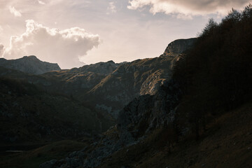 Beautiful mountain landscape with people hiking under the sun 