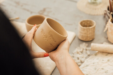 Cropped shot of unrecognizable child making ceramic mug at pottery class