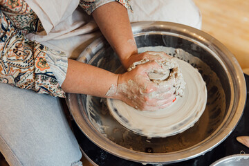 Cropped shot of unrecognizable child making ceramic mug at pottery class