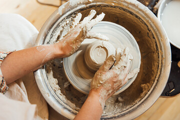 Cropped shot of unrecognizable child making ceramic mug at pottery class