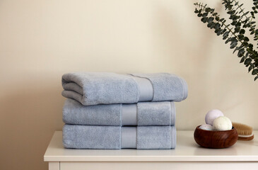 Stack of towels on a dresser with bath bombs 