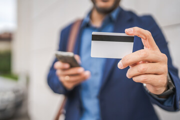 close up of unknown man hold mobile phone and credit card