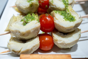 Typical snacks of Basque Country, pinchos or pinxtos skewers with small pieces of bread, fish, sea food, sweet green pepper served in bar in San-Sebastian or Bilbao, Spain