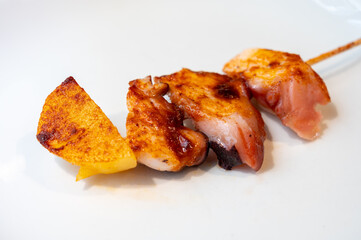 Typical snacks of Basque Country, pinchos or pinxtos skewers with small pieces of bread, fish, sea food, sweet green pepper served in bar in San-Sebastian or Bilbao, Spain