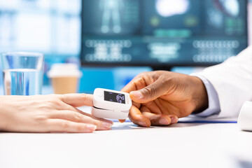 African american medic measuring the oxygen levels and saturation for a female patient, using a modern oximeter and medical technology for a diagnostic report. Oximetry readings. Close up.