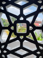 A window with a black frame and a white background. The window is open and the view is of a city