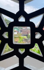 A window with a black frame and a white background. The window is open and the view is of a city