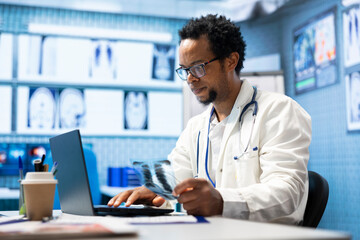 African american doctor analyzing radiography test results for recovery plan, consulting healthcare...