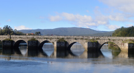 Fototapeta premium Ancient bridge on a river located in Pontevedra, Spain, reflection in the water, pilgrimage to Santiago