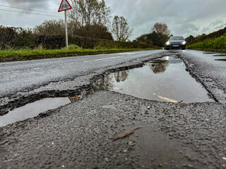 Rain-filled potholes on a rural road in the UK.  