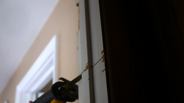 Contractor uses reciprocating saw to cut through old door jamb - 2
