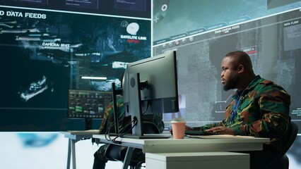 Military team in a control center uses advanced technology to gather crucial information, satellite surveillance systems to support strategic planning. Potential threats on big screen. Camera B.