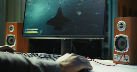 Gamer using keyboard and wired mouse to play videogames on desktop PC, close up shot. Man playing...