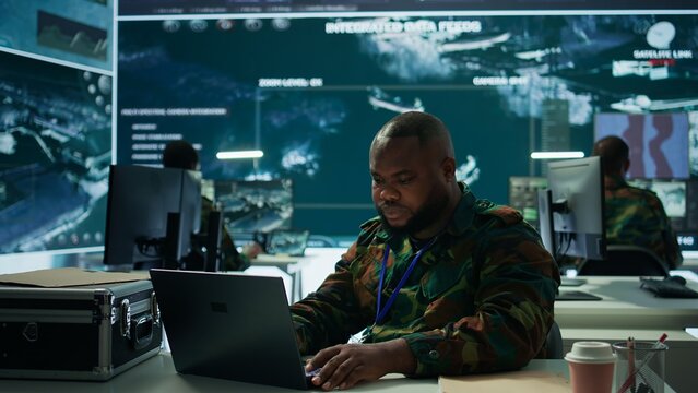Military intelligence specialist uses high tech satellite systems and cctv radar to ensure national protocols, strategic missions for defense operation in command post control tower. Camera B.