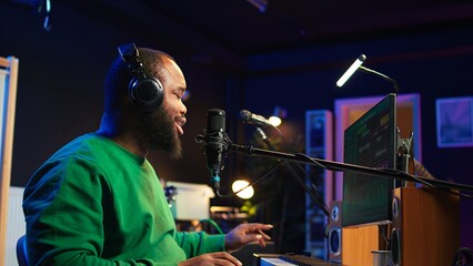 Musician singing his new melody creation on microphone, manipulating his recordings with mix and...