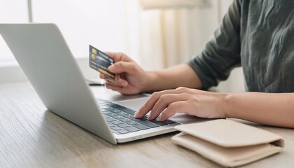 hands using a laptop with a credit card, the process of making an online order