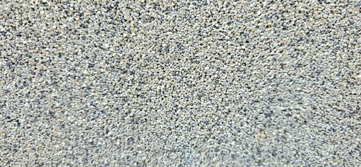 A lot of small pebbles lie on a path in the park. Preparing the road for leveling. Stone background