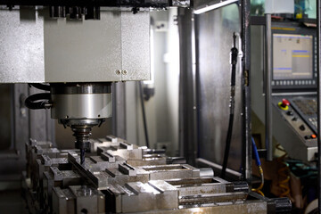 Cnc milling machine carving metal part in factory workshop