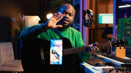 Talented performer teaching how to play acoustic guitar online for a tutorial, hosting internet master class to provide advice for beginners. Artist composer explaining accords on strings. Camera A.