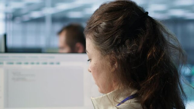 Smiling IT engineer in data center using PC to find misconfigurations affecting rackmounts. Cheerful woman checking servers bottlenecks leading to sluggish data transfer rates, camera A close up