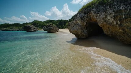 青い空の下、澄んだ水と岩の崖が広がる美しい熱帯のビーチ