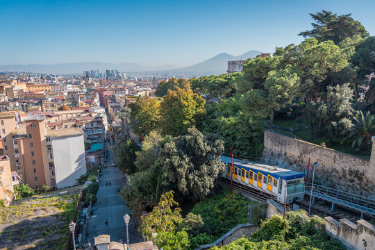 Funicular riding from the lower part of the napoli city towards the saint elmo fortress above the ground. Visible panorama of the napoli city with the white and blue funicular