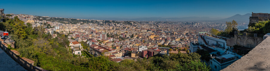 Fototapeta premium Panoramic view of mount vesuvius and the city of naples below, looking from Sant elmo castle above the city. Summer or autumn scene with majestic volcano view
