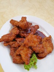 Vertical view .Chinese Pork chop in tomato sauce served on a white plate.Popular chinese food