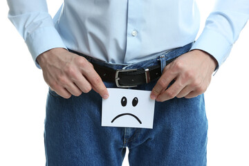 STD (sexually transmitted diseases). Man holding sticky note with drawn sad face on white...