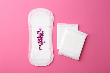 Menstrual pads and sequins on pink background, top view © New Africa