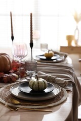 Stylish table setting with beautiful dishware and autumn decor in dining room