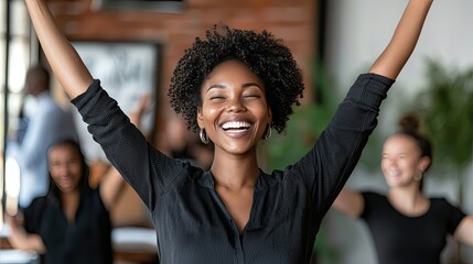 Joyful woman celebrating success with arms raised in a lively environment.