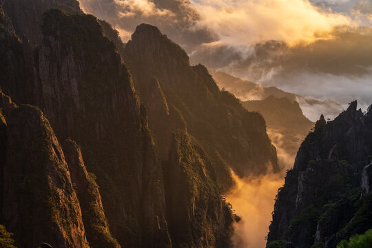 Autumn scenery of Huangshan Mountain, including rocks, sea of ​​clouds at sunset, and pine trees.